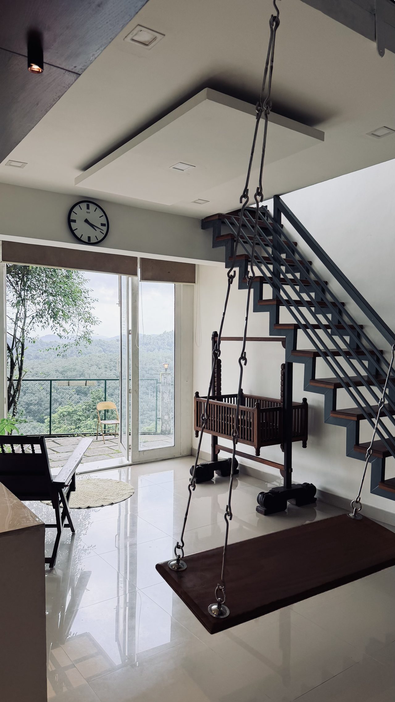 The double-height hall, staircase to the majlis, and hanging swing